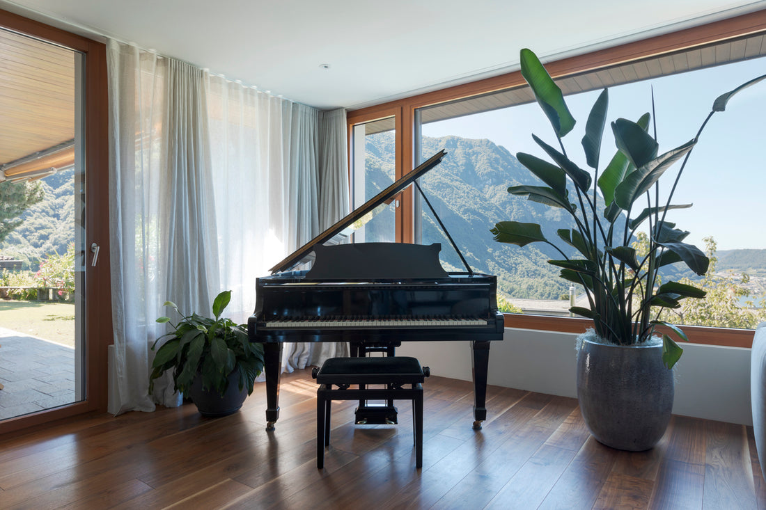 Panoramafenster mit Klavier und Blick auf die Berge in modernem Wohnraum