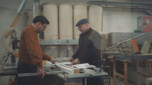 Architekt und Schreiner besprechen Fensterplanung in Werkstatt, Beratung und Zusammenarbeit